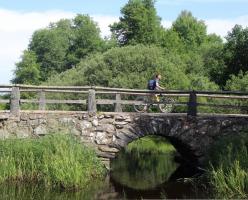 Bicyclist on Stone Arch Bridge in Tingsryd
